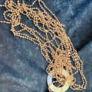 Many-strand small likely pink pearl necklace with a mother-of-pearl loop.